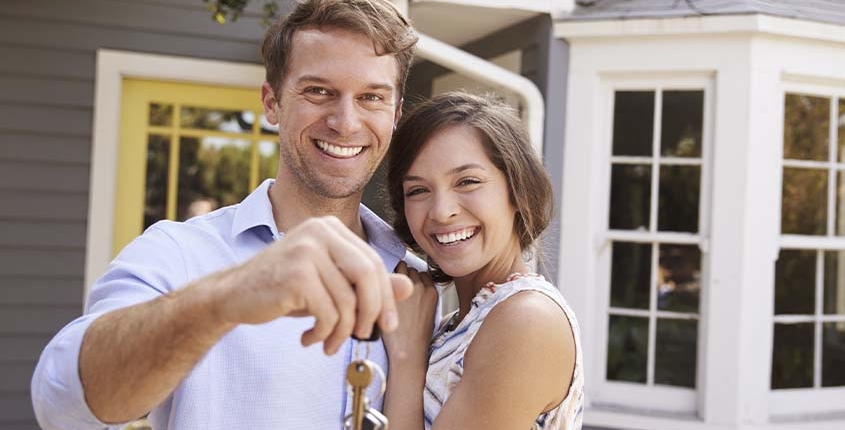 happy couple holding the keys to their new home