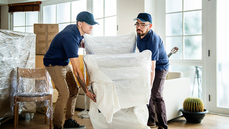 moving companies iowa two men moving a padded and shrink wrapped chair