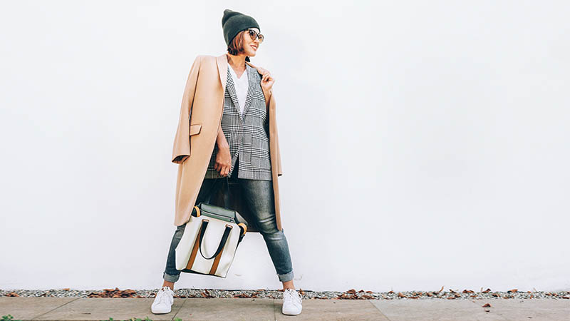 woman wearing many items to save space in her suitcase