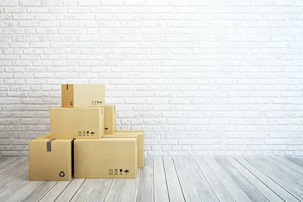 several small boxes stacked by themselves in a room with brick wall and wood floor